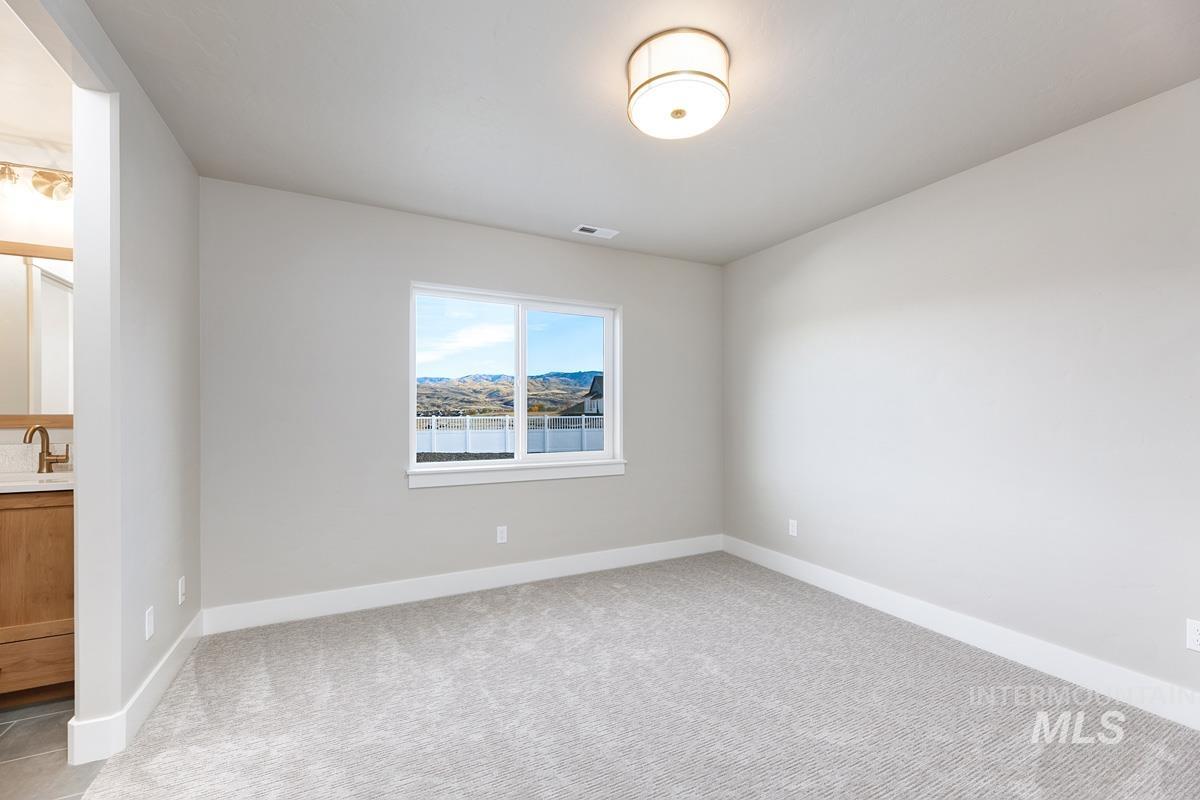 Spare room with light colored carpet and baseboards