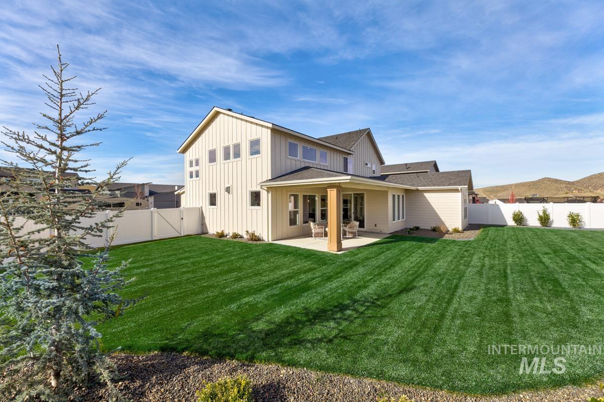 Rear view of property with a patio area, a gate, board and batten siding, and a fenced backyard