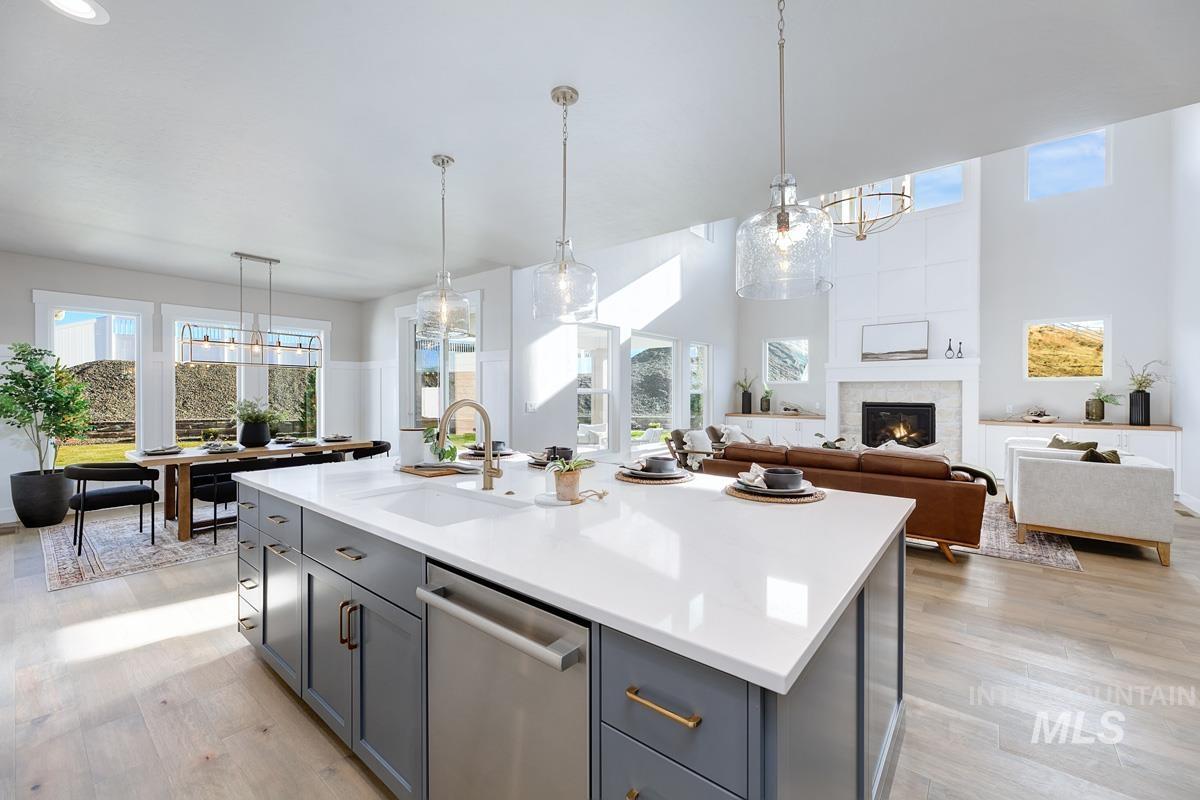 Kitchen with decorative light fixtures, a chandelier, dishwasher, and a towering ceiling