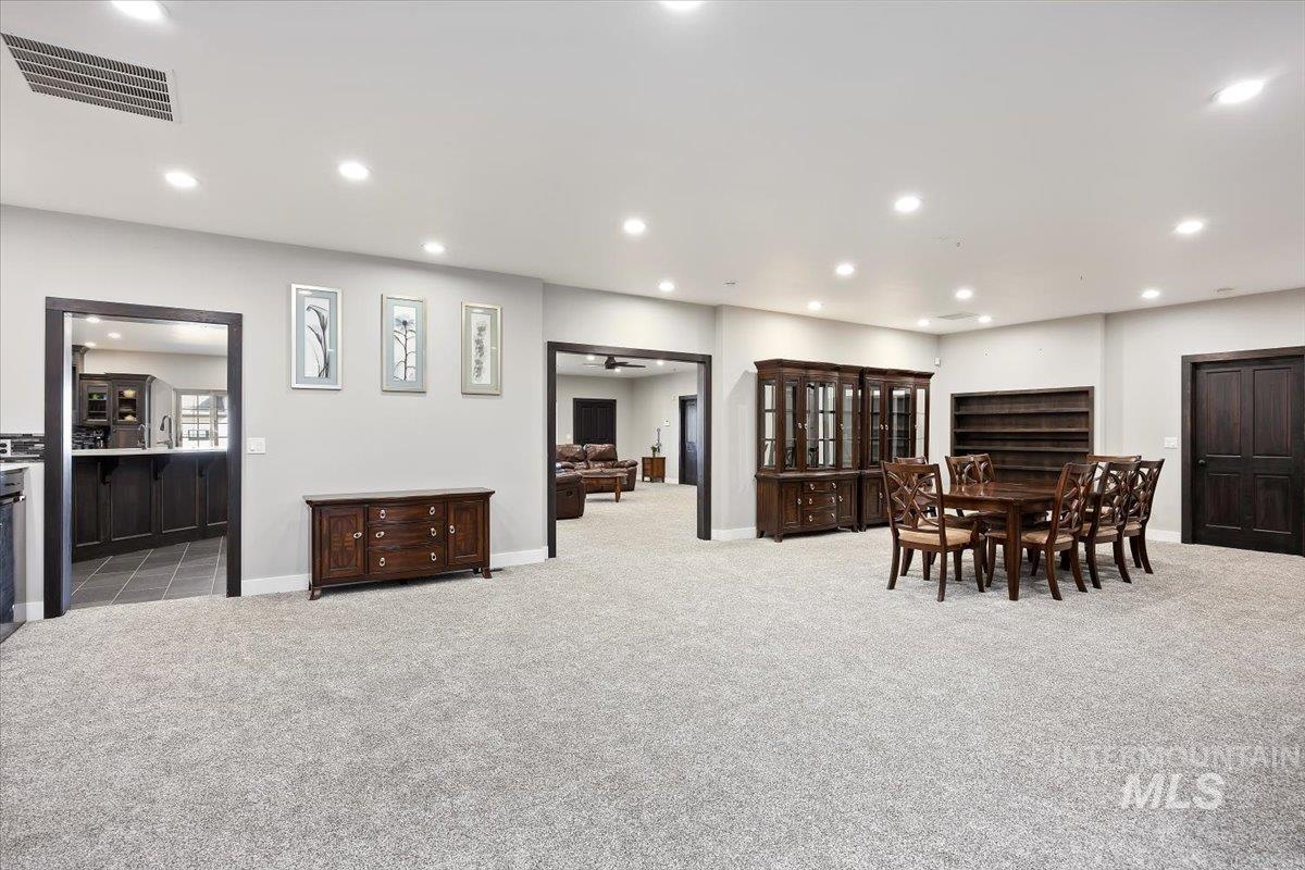 Dining room with recessed lighting and light carpet