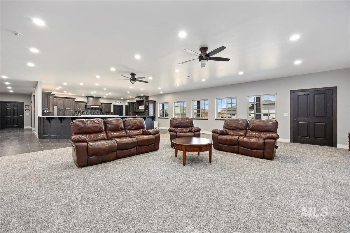Living area with carpet flooring, recessed lighting, and a ceiling fan