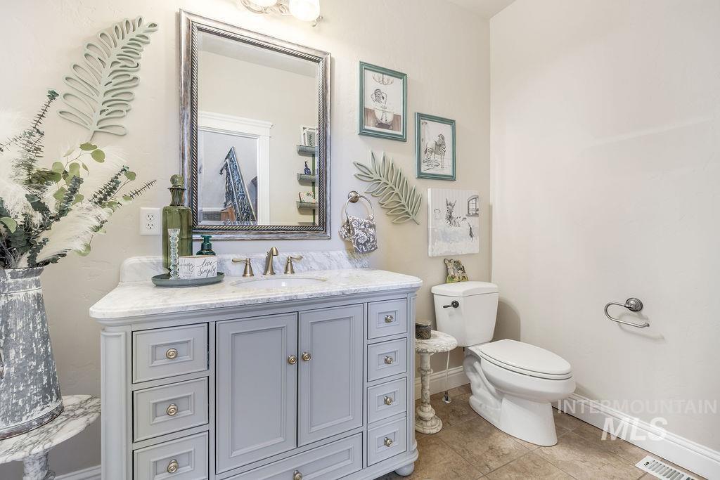 Half bath featuring vanity and light tile patterned floors