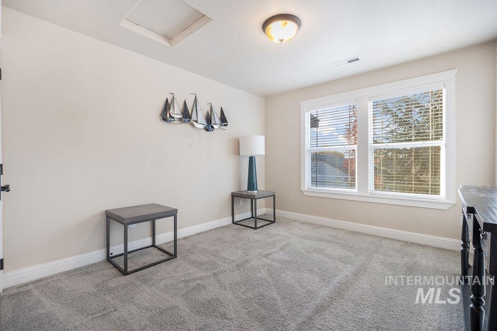 Spare room featuring light carpet and attic access