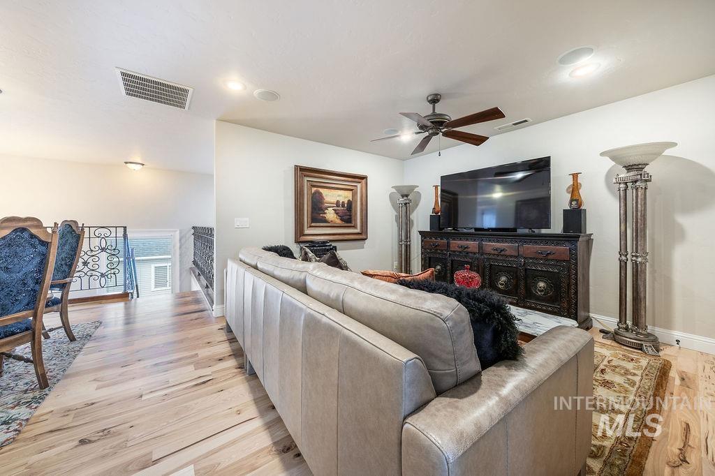 Living area with light wood finished floors, a ceiling fan, and recessed lighting