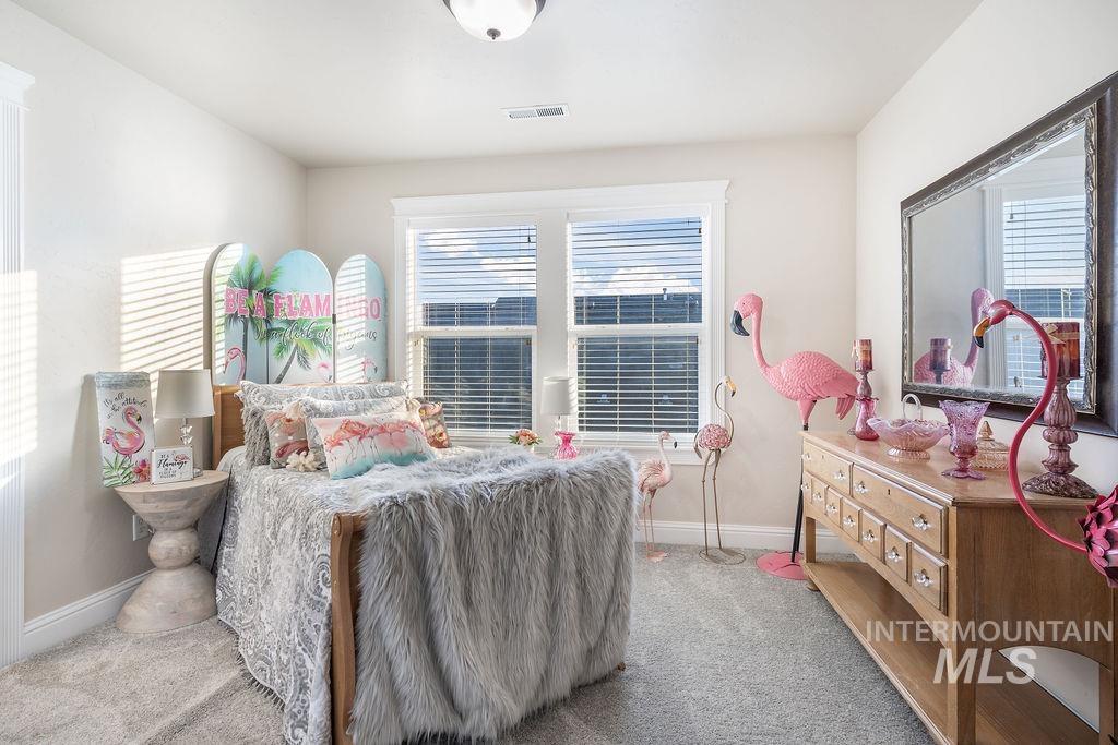 Bedroom featuring light carpet
