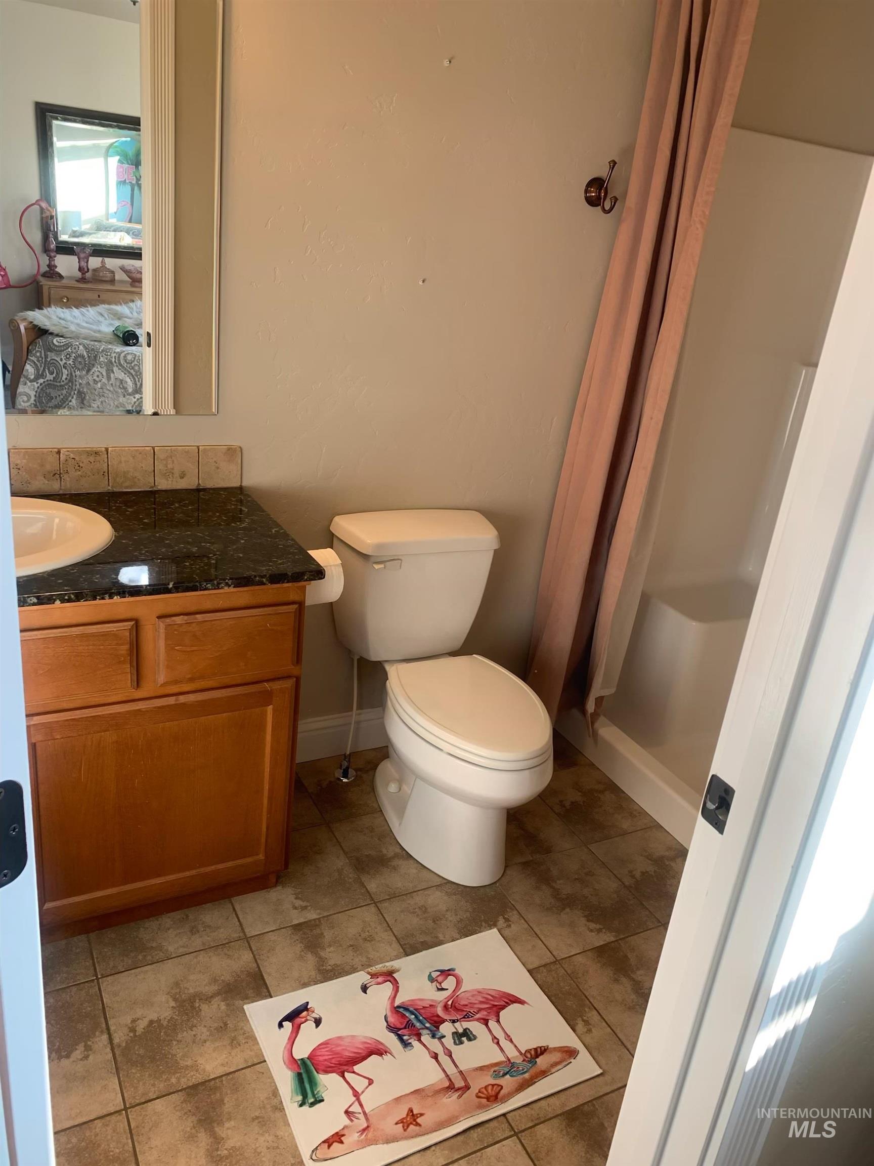 Bathroom with a shower stall, vanity, and light tile patterned floors