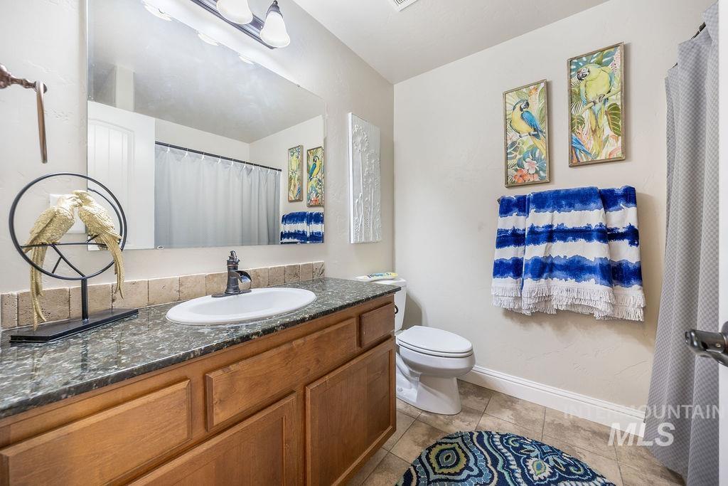 Full bathroom with a shower with curtain, vanity, and light tile patterned flooring