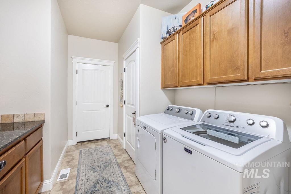 Laundry area featuring cabinet space and washer and clothes dryer