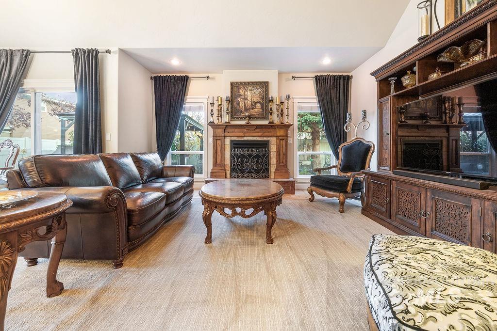 Living area with a fireplace, recessed lighting, and lofted ceiling