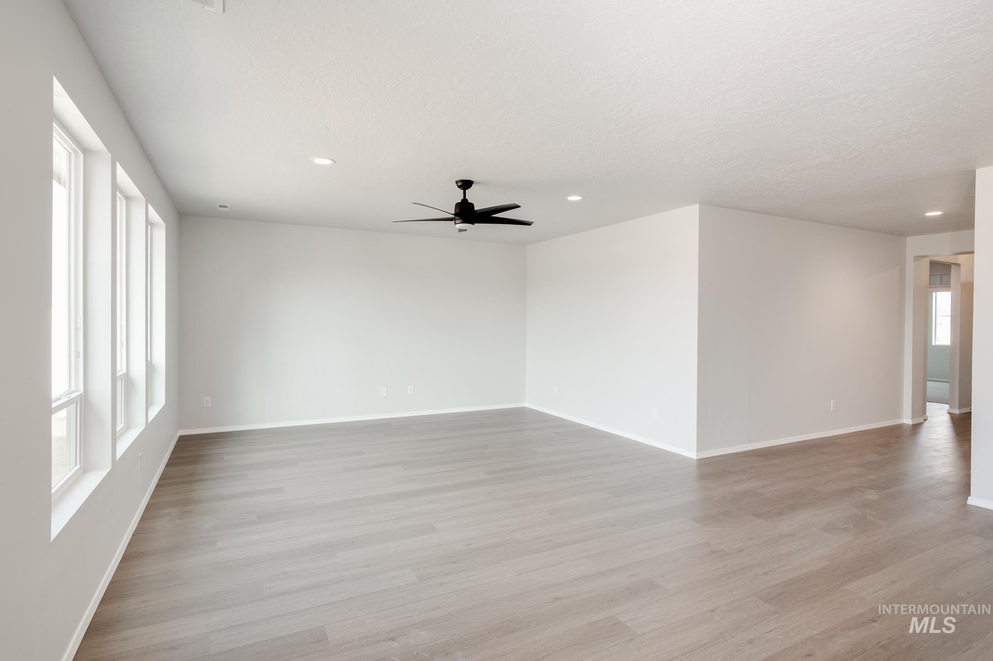 Spare room featuring light wood finished floors, recessed lighting, and a ceiling fan