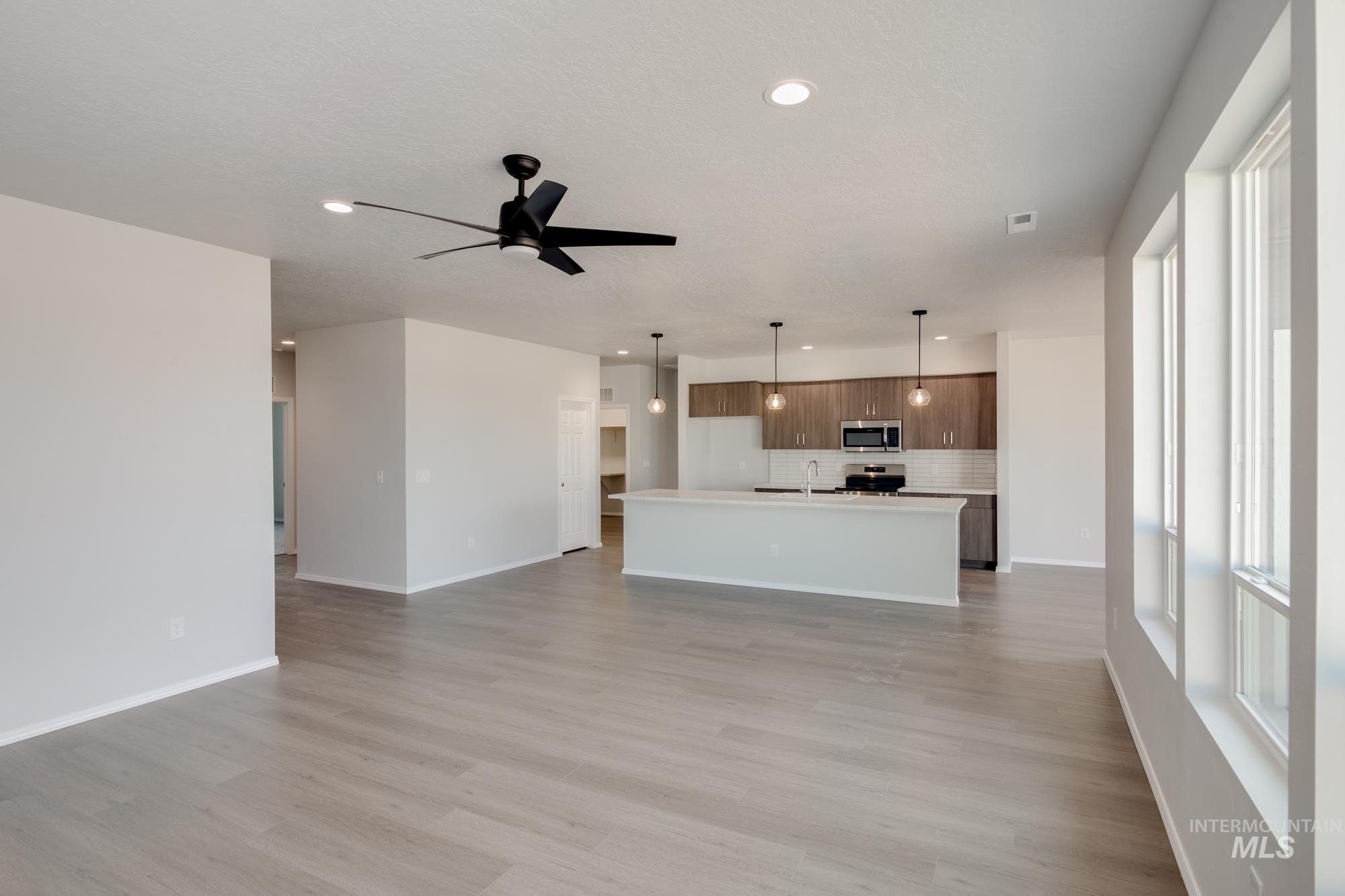 Unfurnished living room with light wood-type flooring, recessed lighting, and ceiling fan