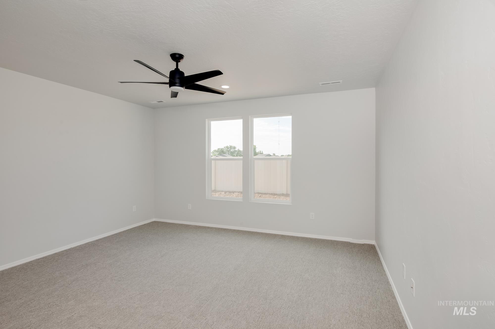 Spare room with light colored carpet and ceiling fan