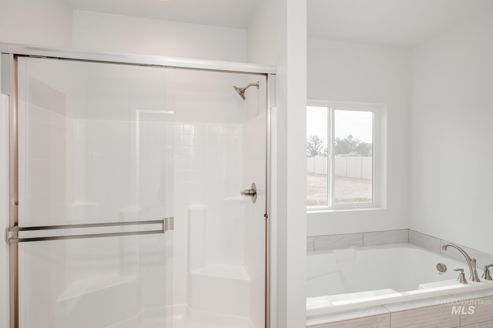 Bathroom featuring a garden tub and a stall shower