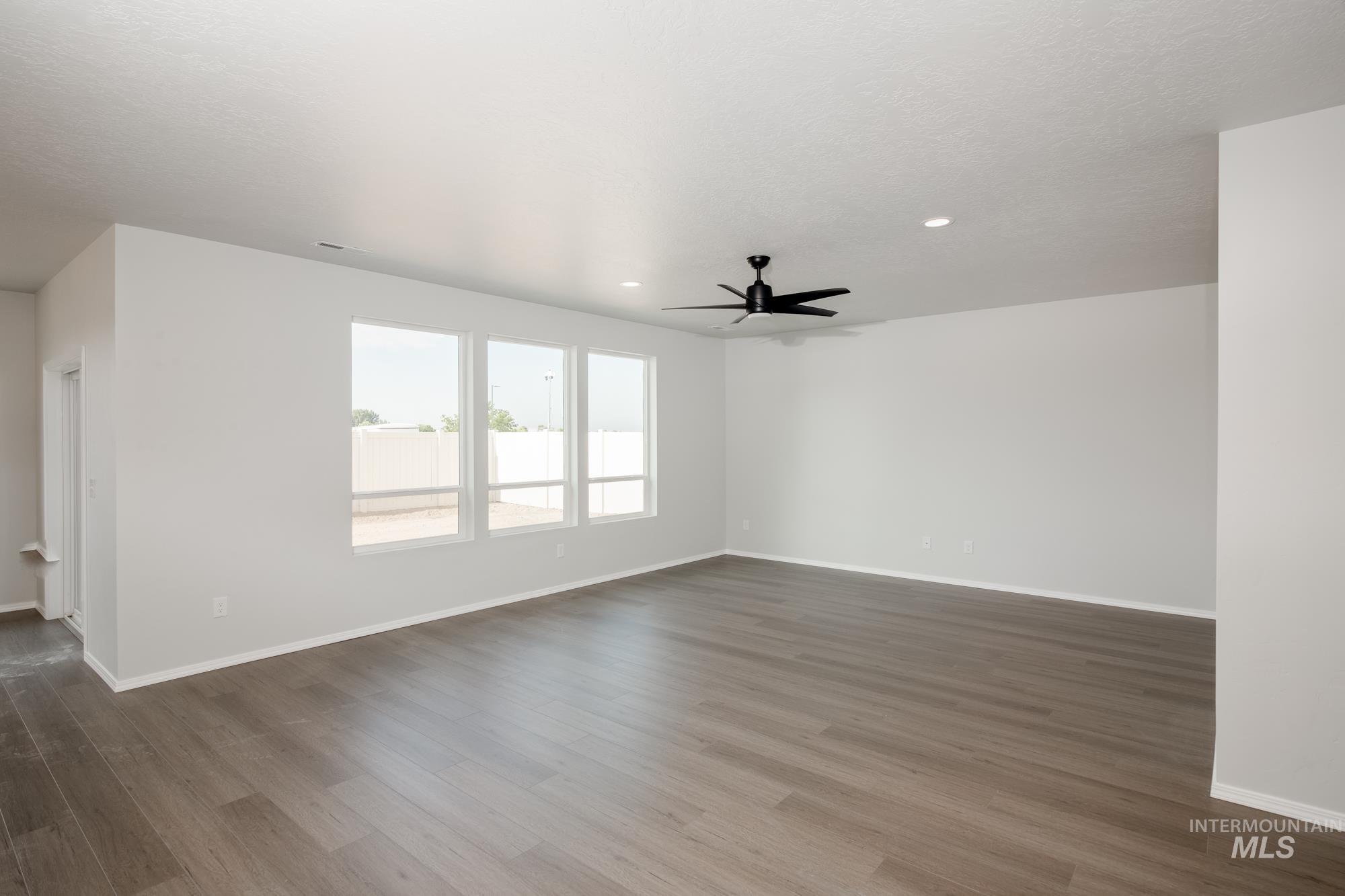 Empty room with dark wood finished floors, recessed lighting, and ceiling fan