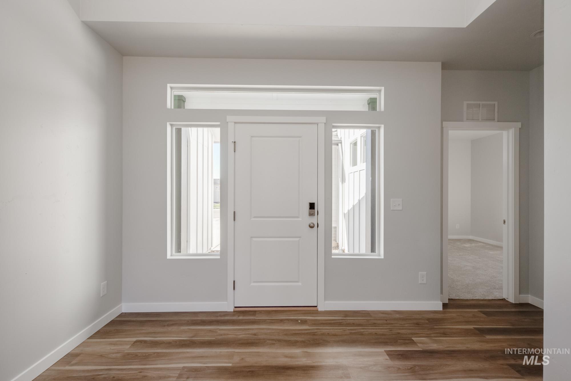 Entryway with wood finished floors and baseboards