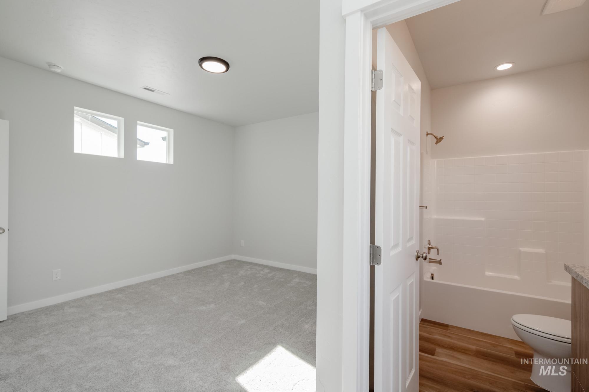 Bathroom with shower / washtub combination, vanity, and light carpet