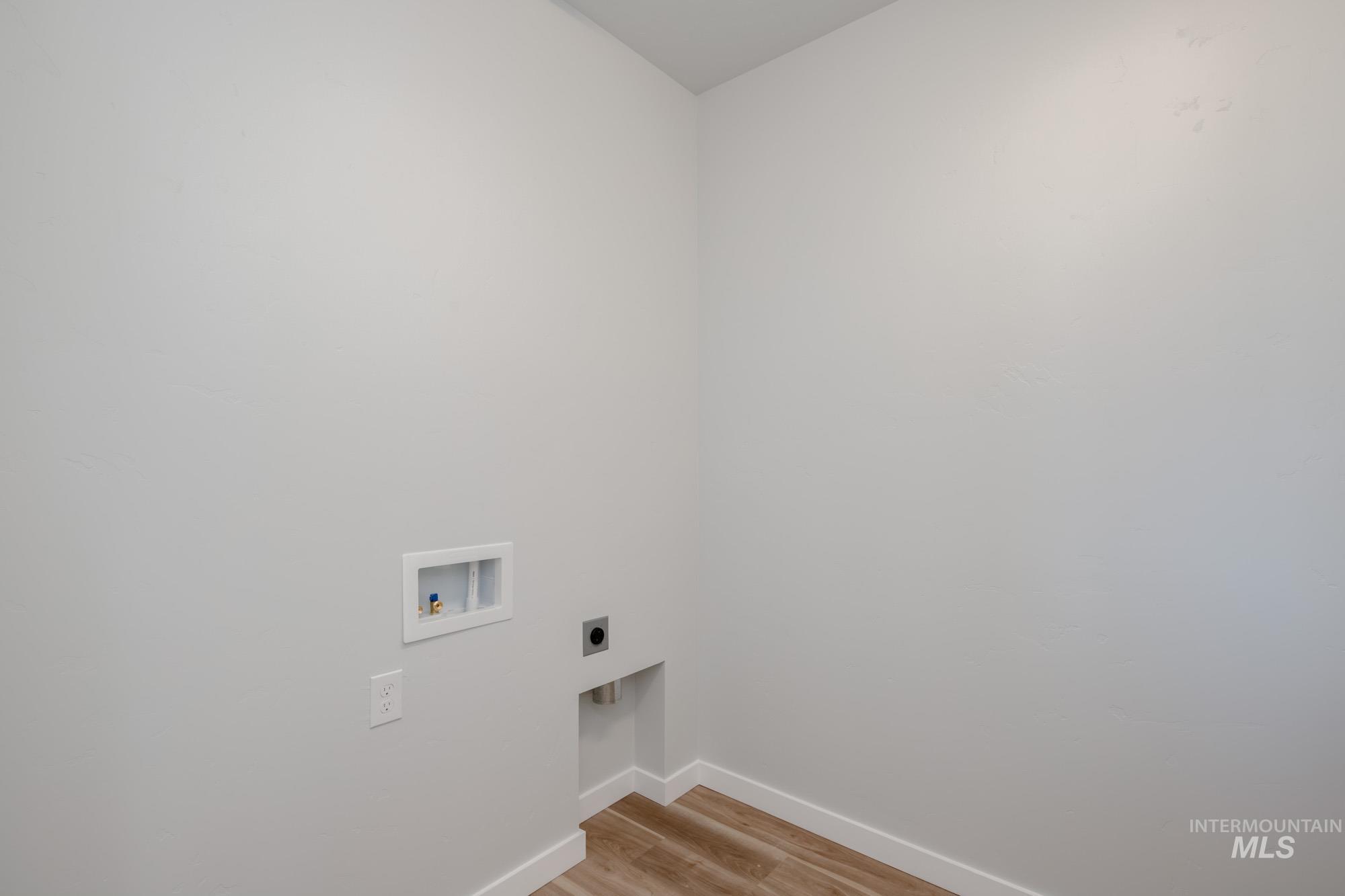 Laundry area featuring light wood-type flooring, washer hookup, and hookup for an electric dryer