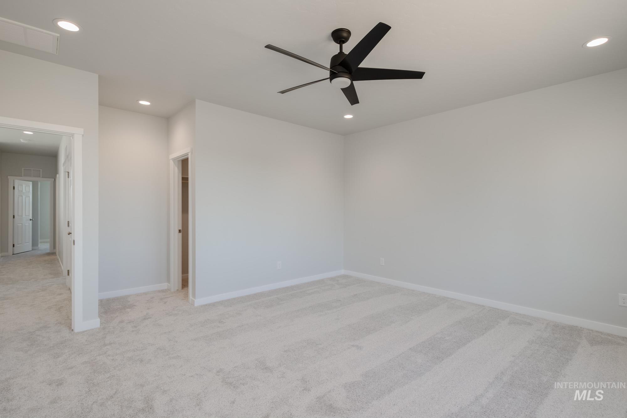 Empty room with light colored carpet, recessed lighting, and ceiling fan