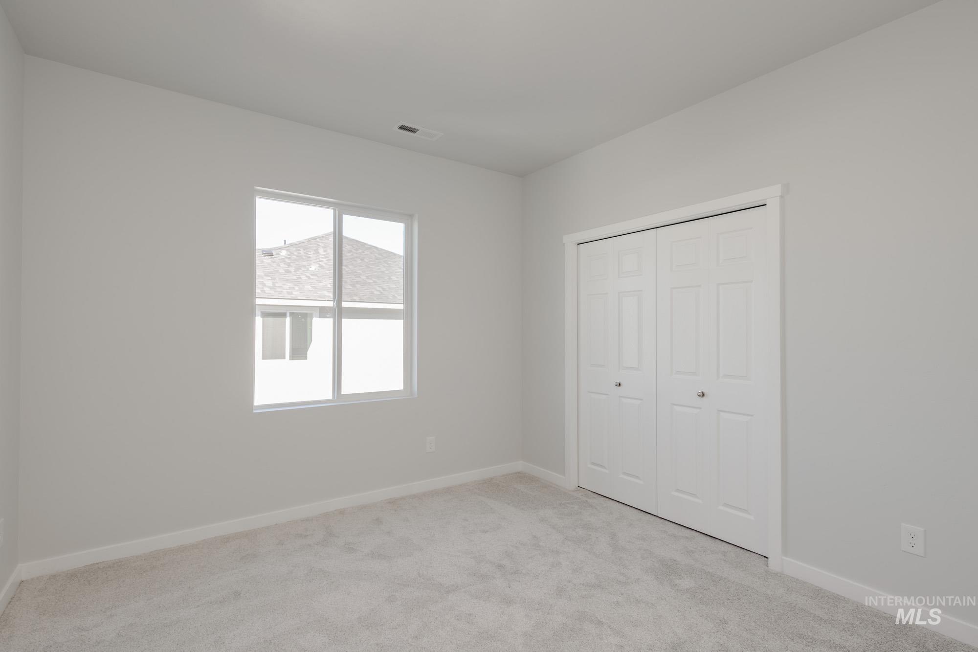 Unfurnished bedroom featuring light colored carpet and a closet