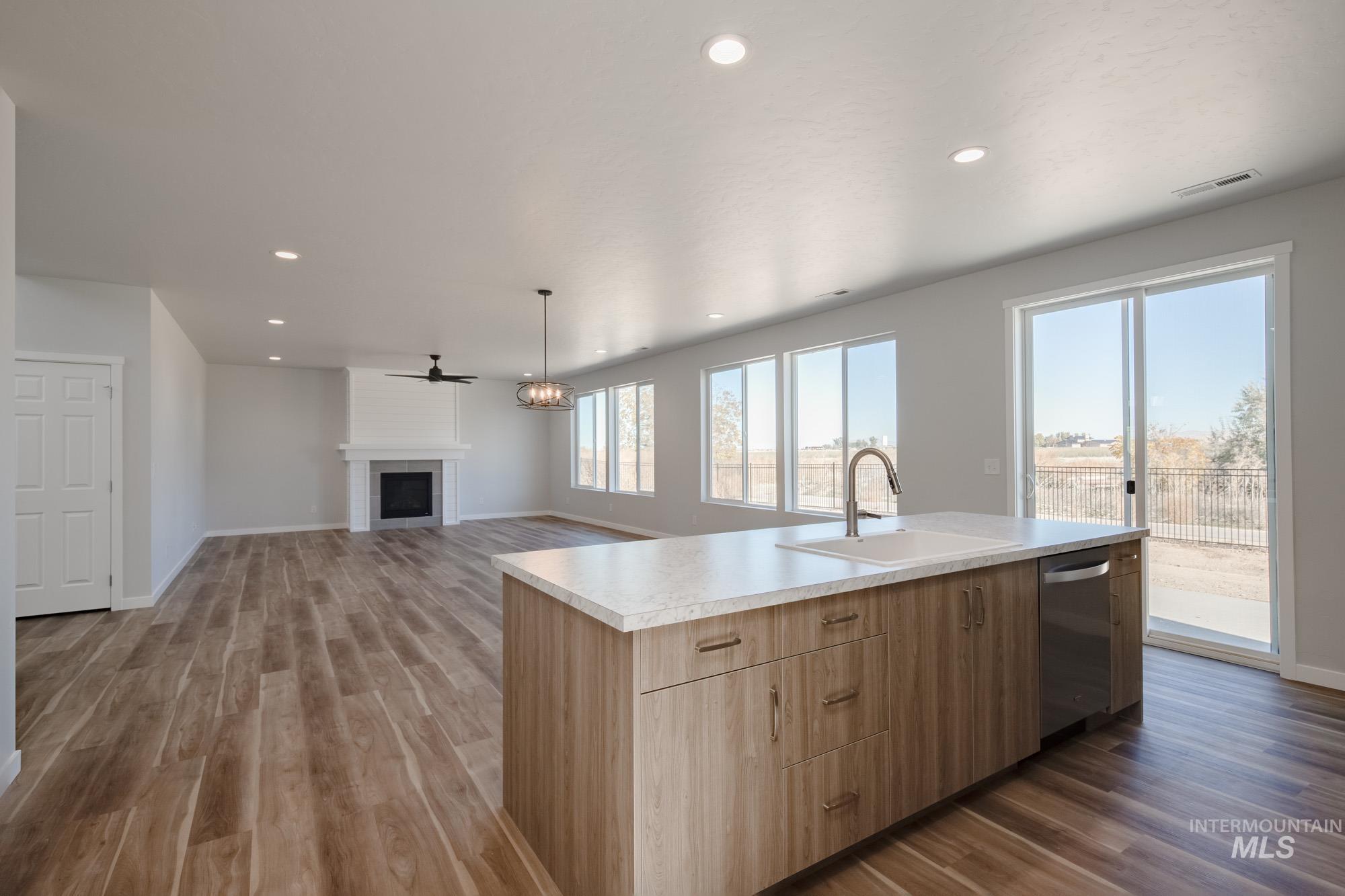 Kitchen with dark wood-style flooring, light countertops, ceiling fan, a chandelier, and recessed lighting