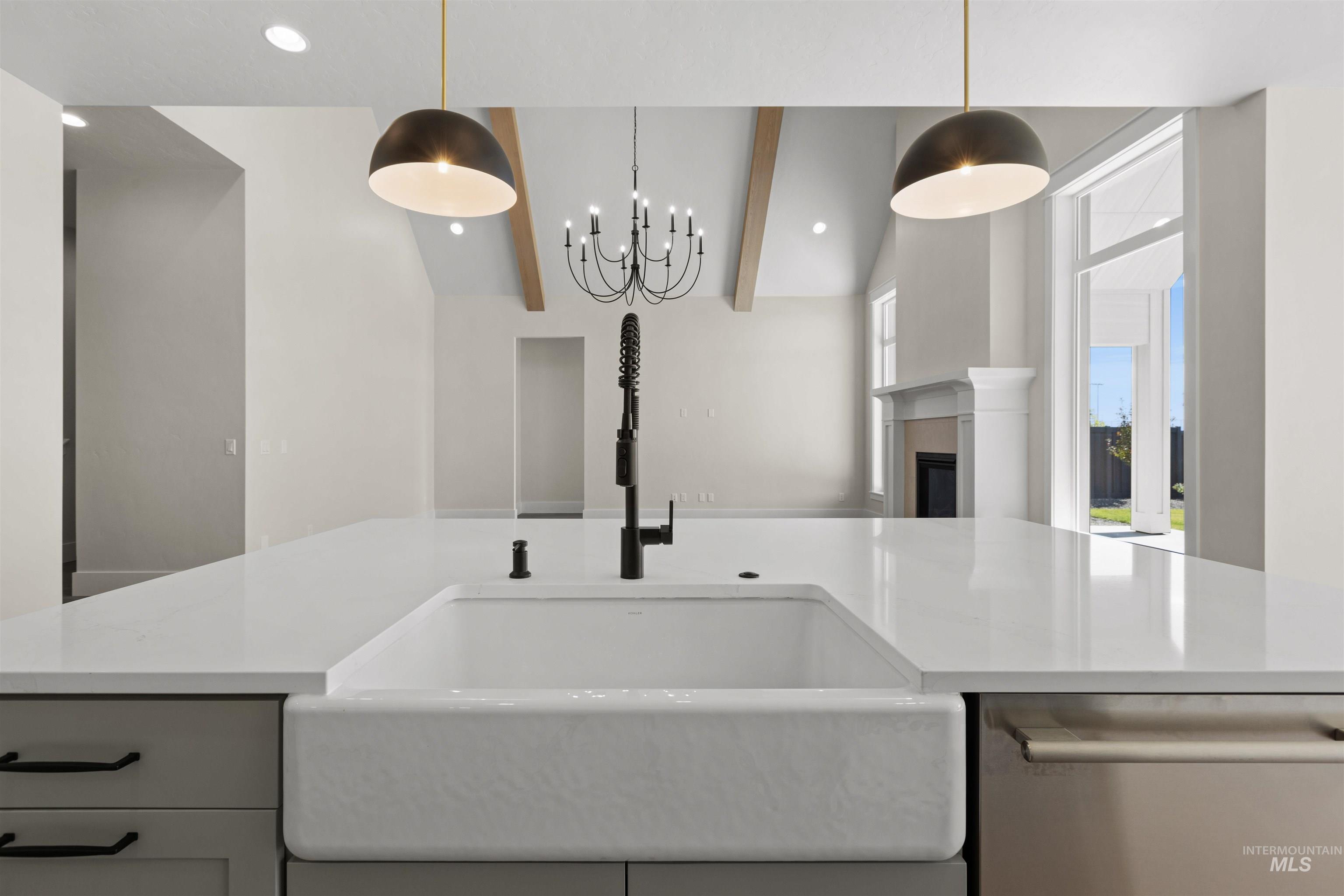 Kitchen with dishwasher, light countertops, open floor plan, decorative light fixtures, and a chandelier