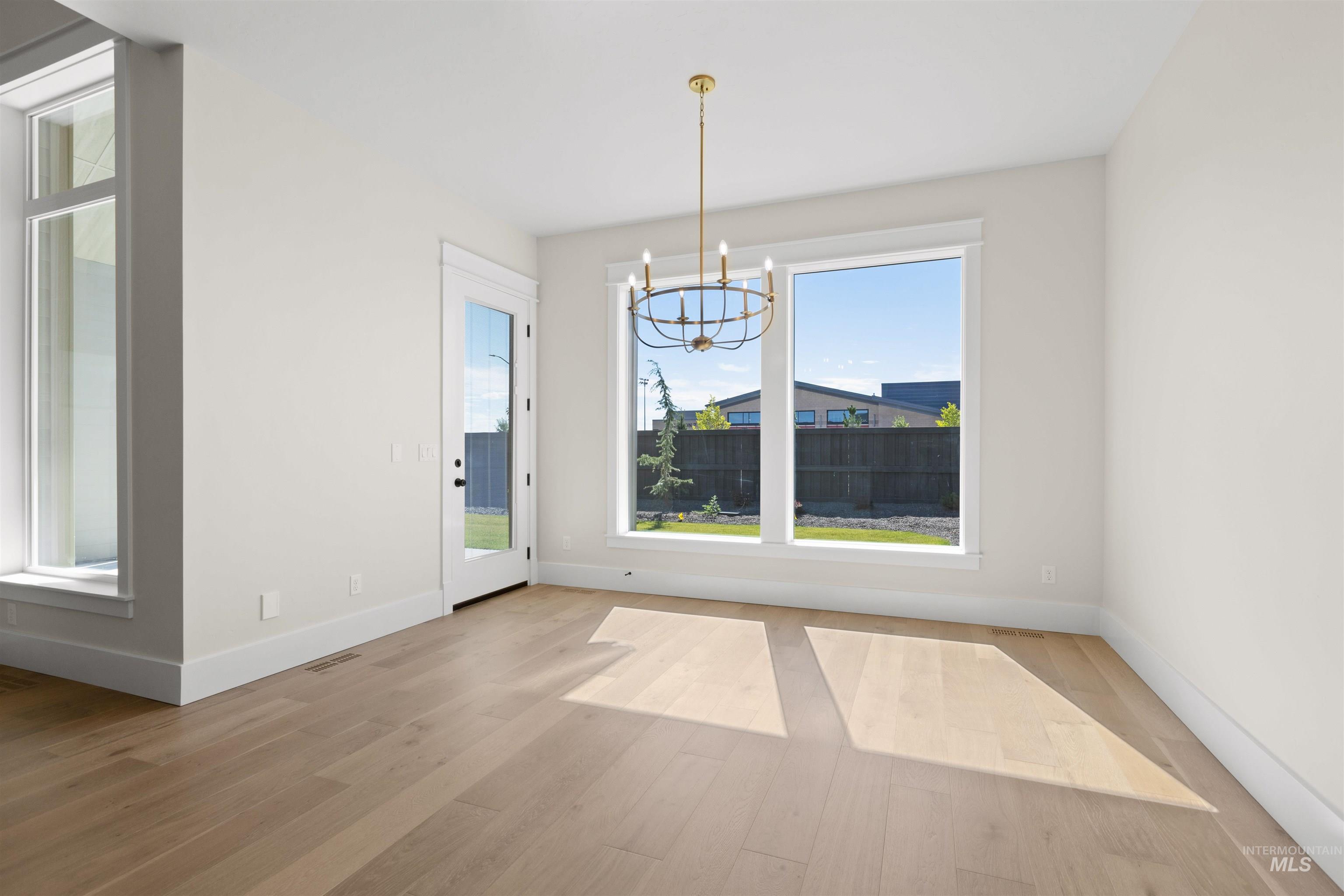 Unfurnished dining area with a chandelier and wood finished floors