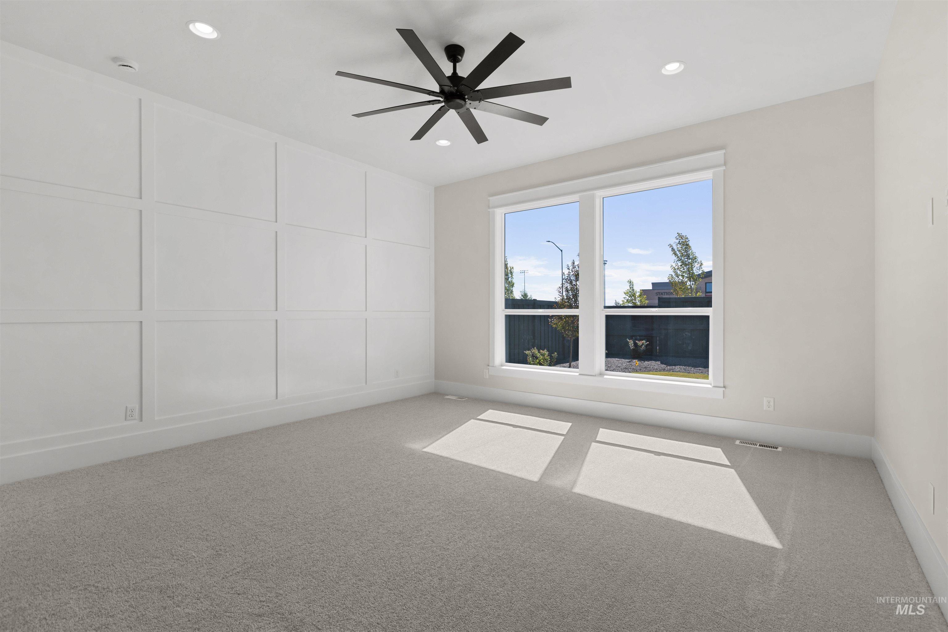 Carpeted empty room featuring ceiling fan and recessed lighting