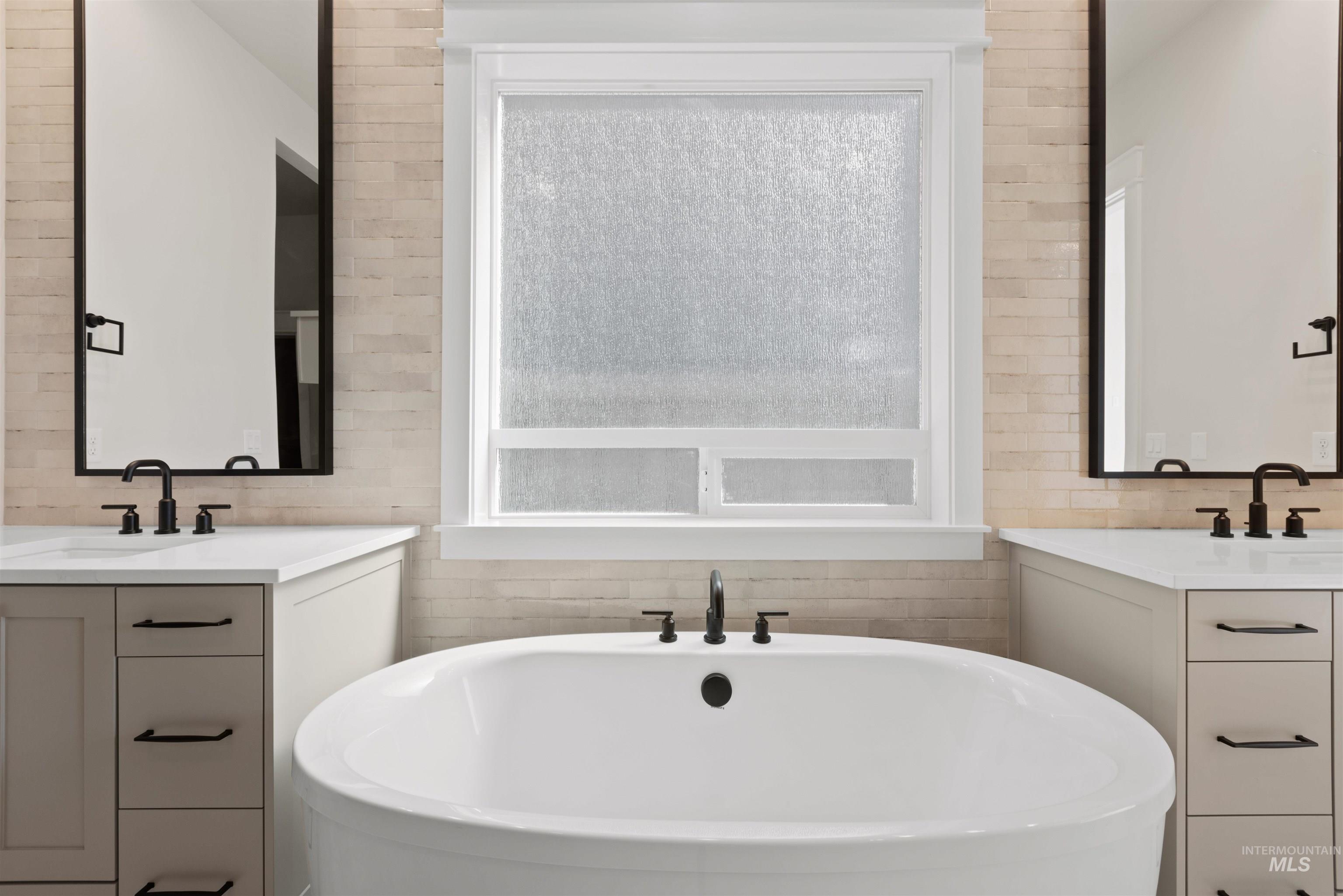 Full bath with a soaking tub and two vanities