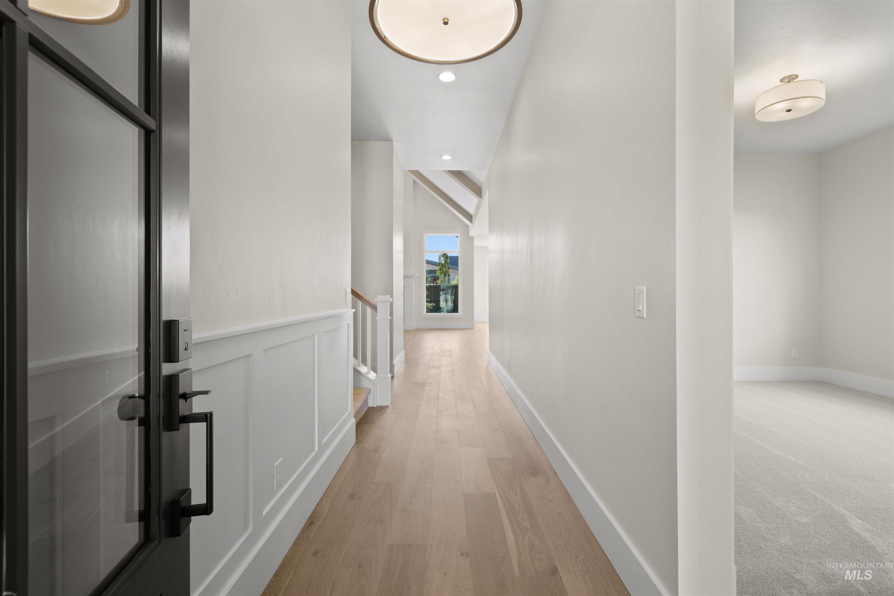 Hall featuring an upstairs landing, light wood-type flooring, and recessed lighting