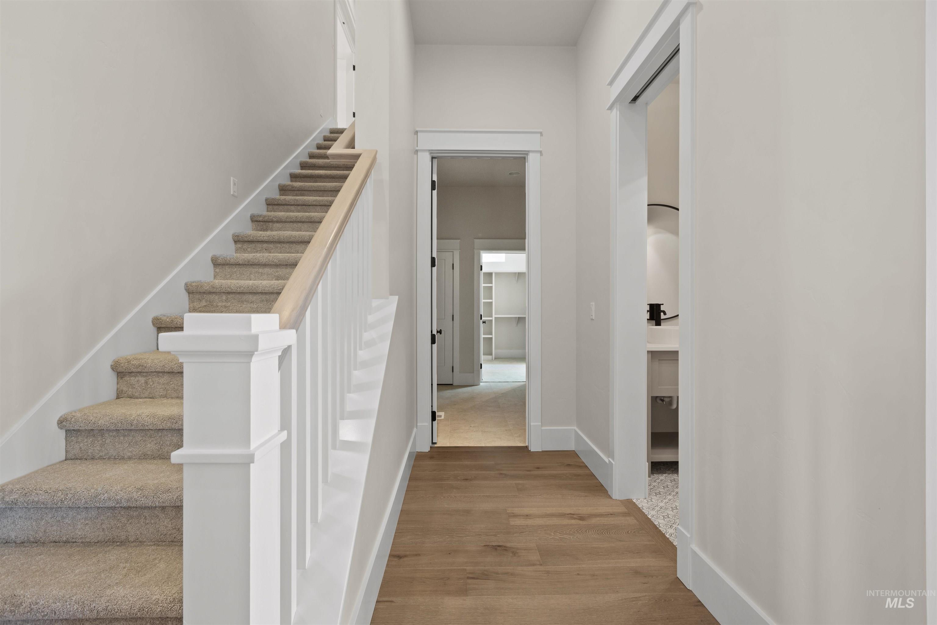 Stairs with wood finished floors and baseboards