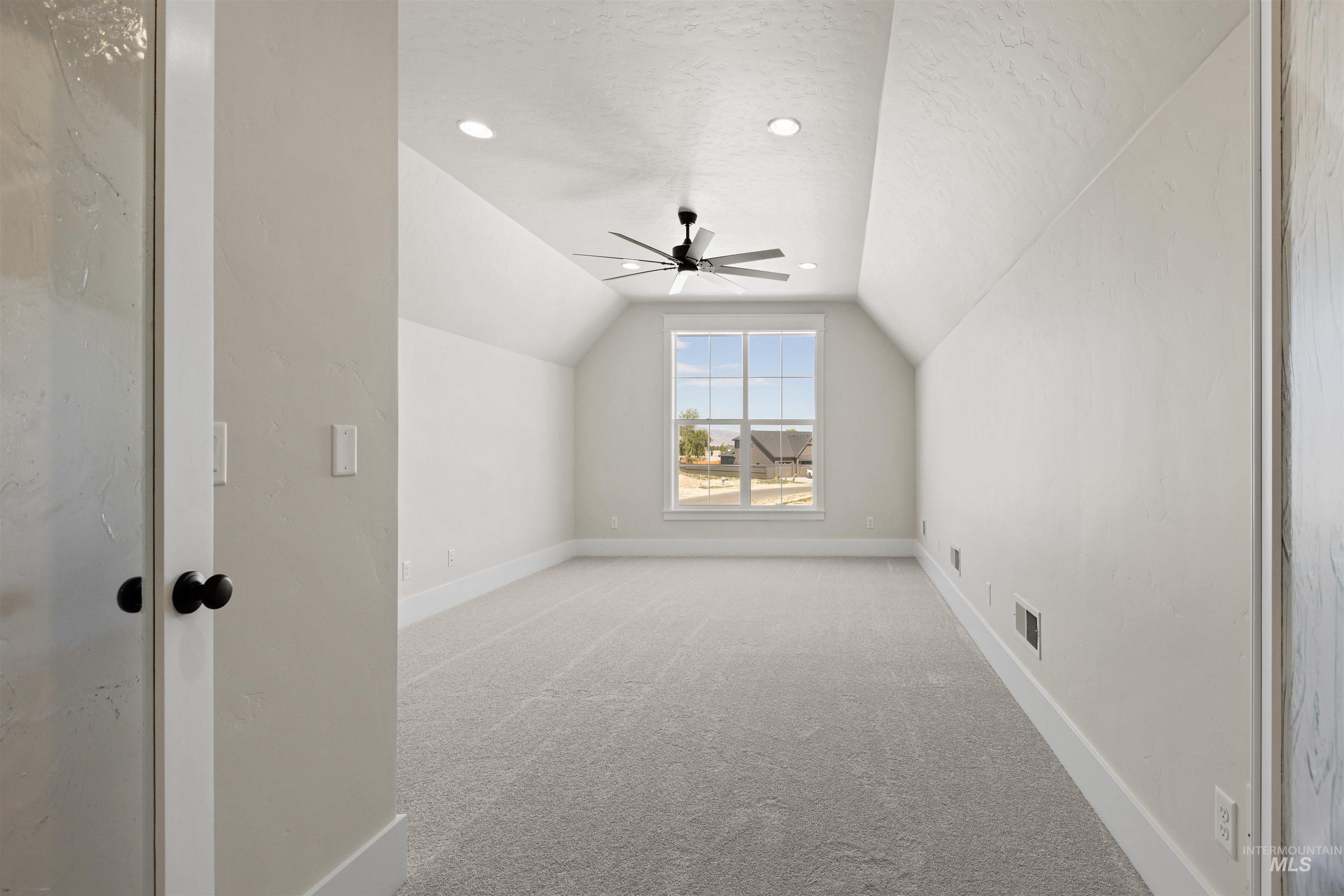 Additional living space featuring vaulted ceiling, light carpet, ceiling fan, a textured ceiling, and recessed lighting