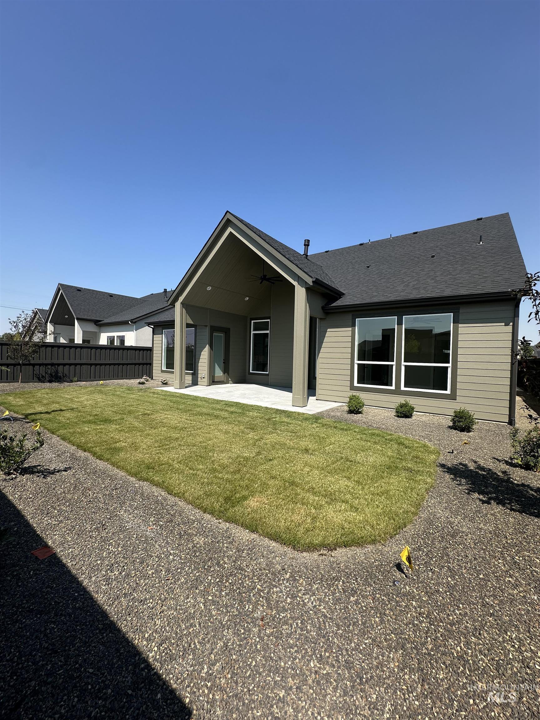 Back of property featuring a patio, a ceiling fan, and a shingled roof