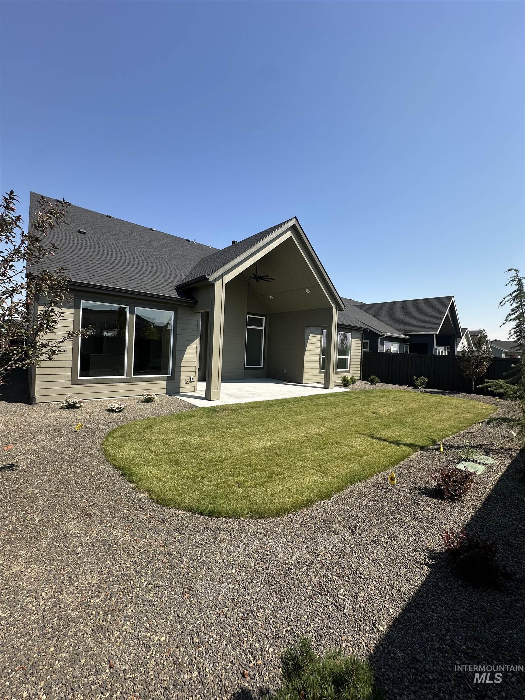 Back of house featuring a patio, ceiling fan, and roof with shingles