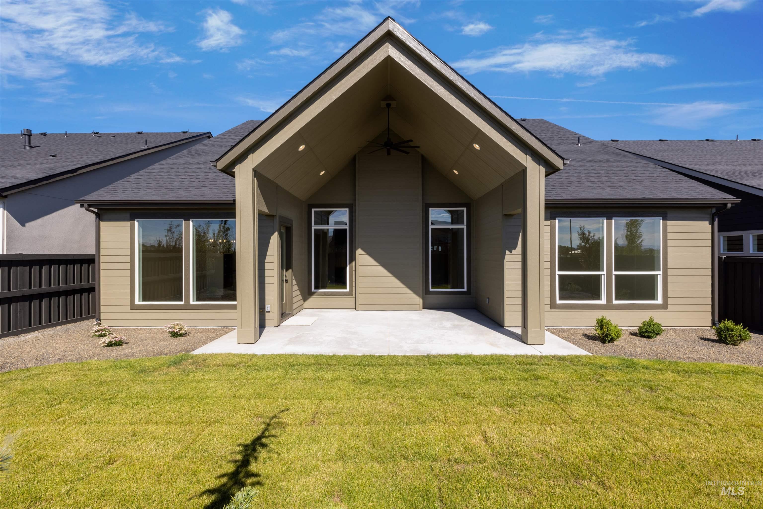 Rear view of house with a shingled roof, a patio area, and a fenced backyard