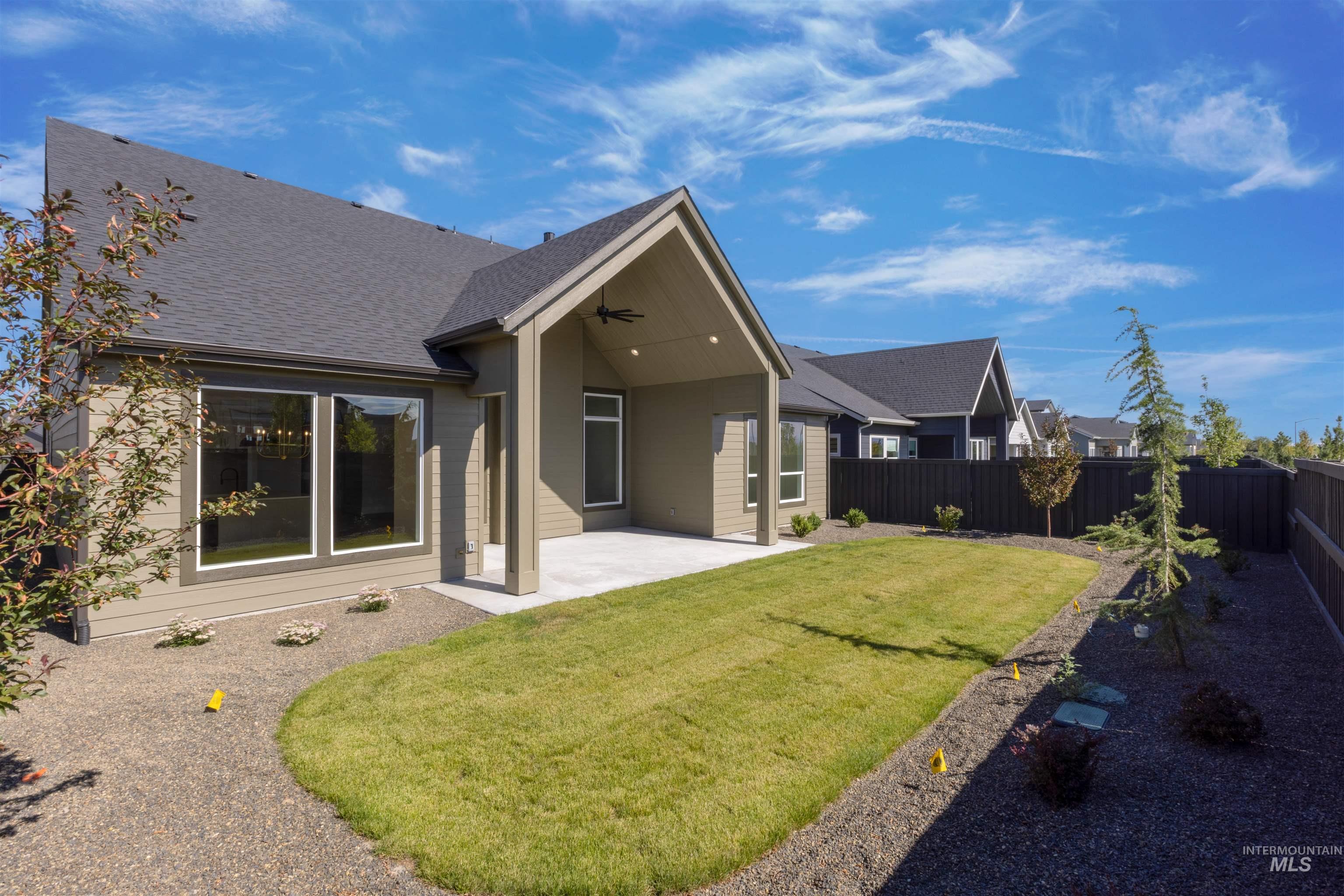 Rear view of house with a shingled roof, a patio area, a fenced backyard, and ceiling fan