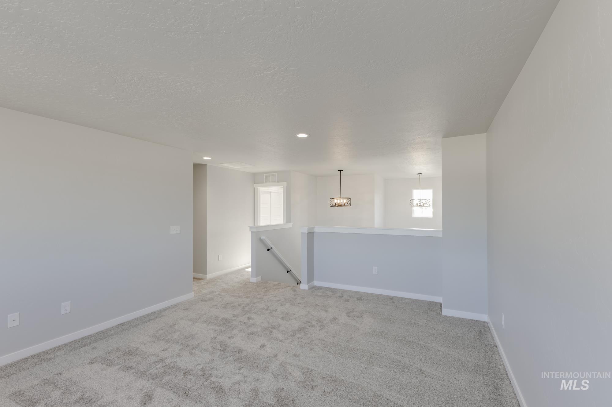 Unfurnished room featuring light carpet, recessed lighting, and a chandelier