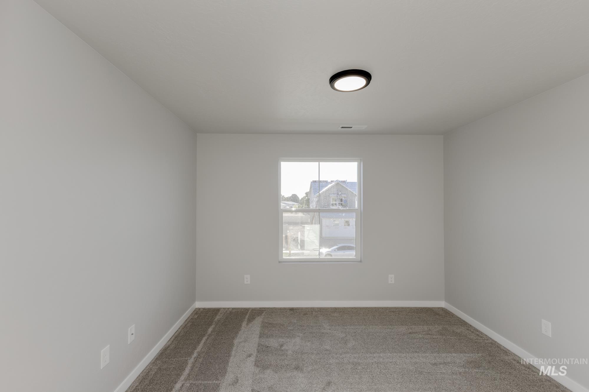 Unfurnished room featuring light carpet and baseboards
