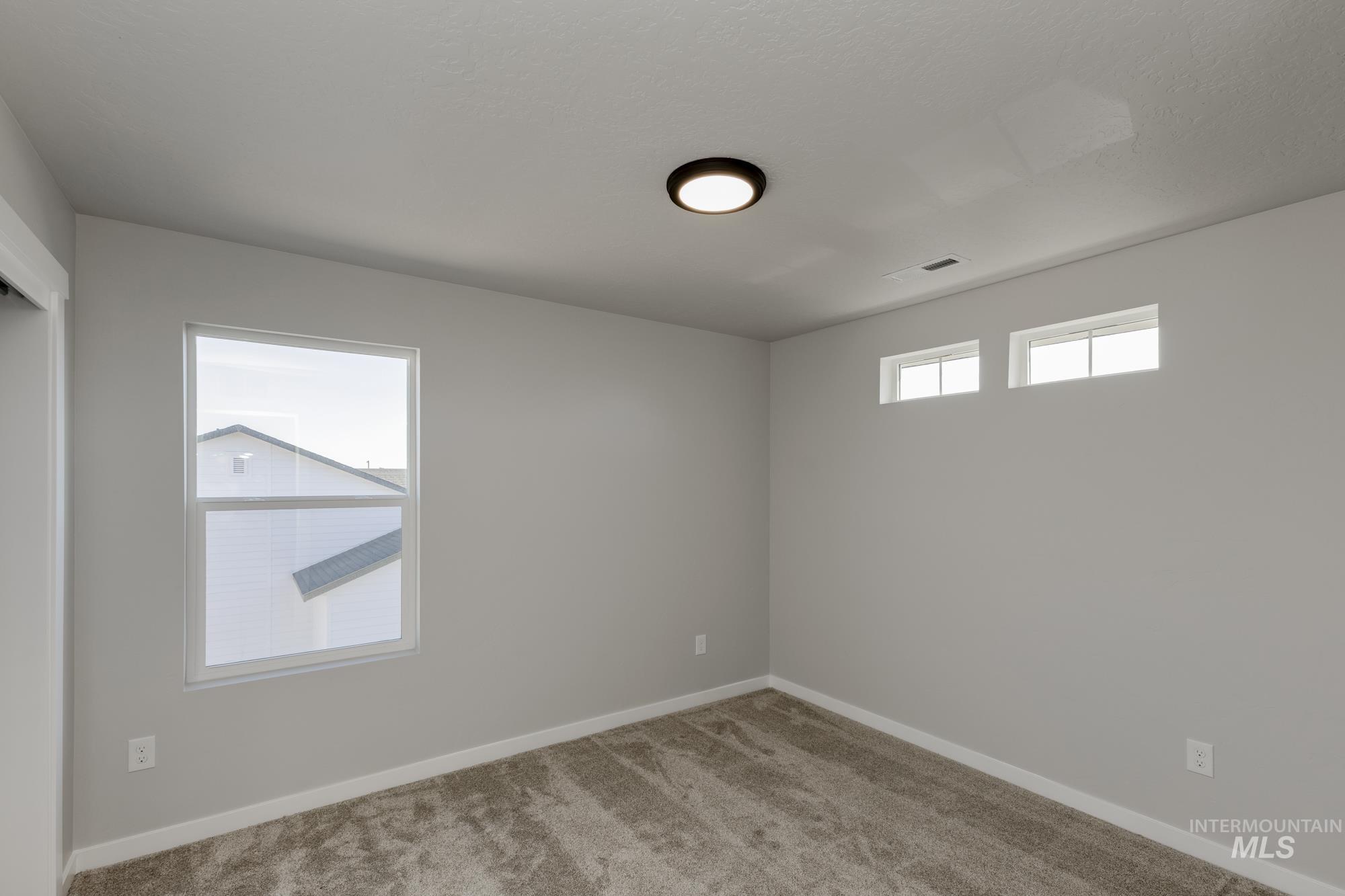 Spare room featuring carpet and baseboards