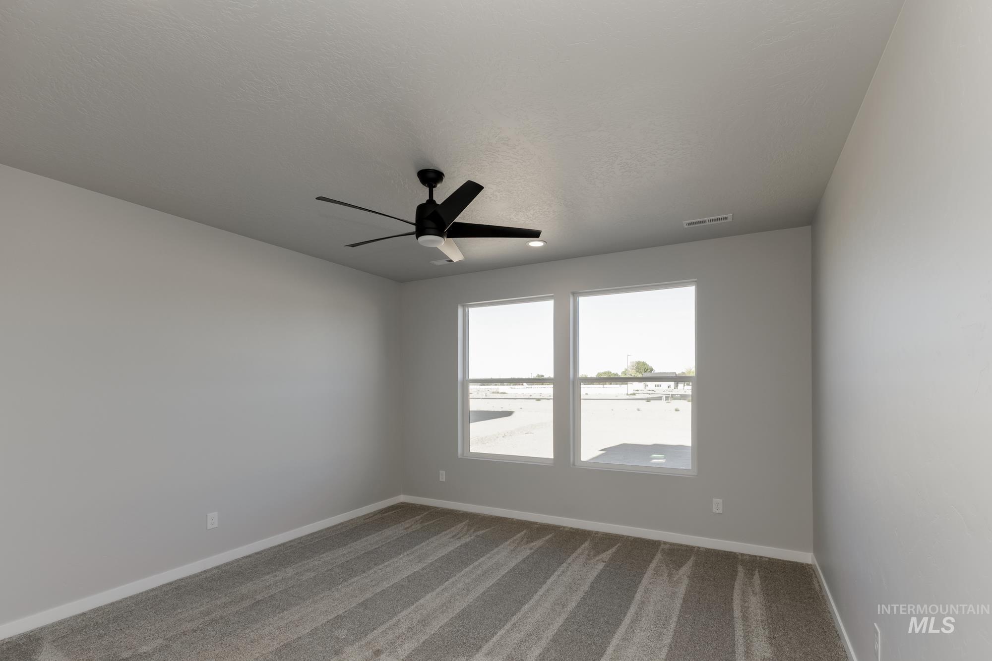 Unfurnished room featuring carpet flooring and ceiling fan