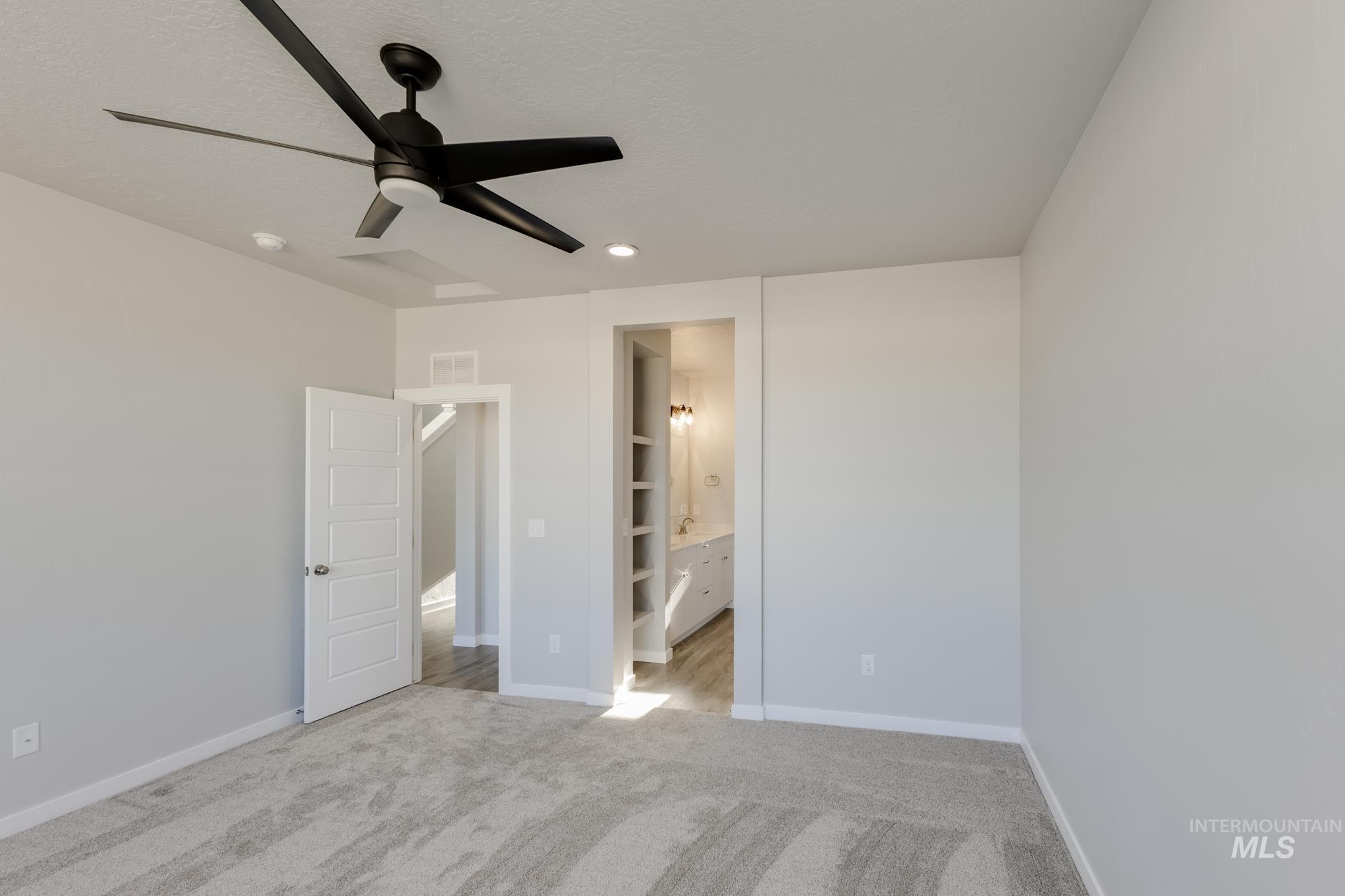 Unfurnished bedroom featuring light colored carpet, a ceiling fan, recessed lighting, and ensuite bath