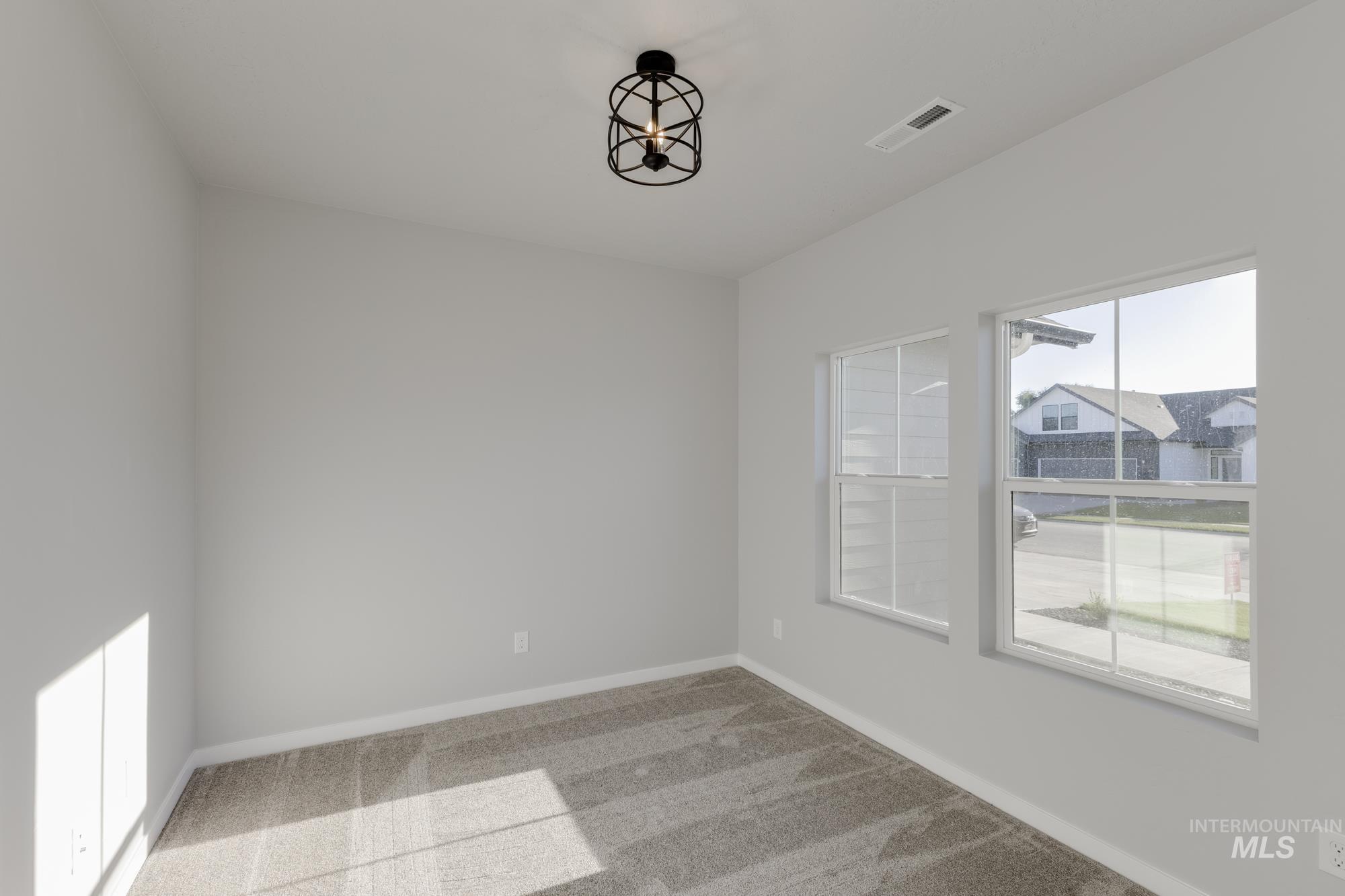 Empty room featuring baseboards and light colored carpet
