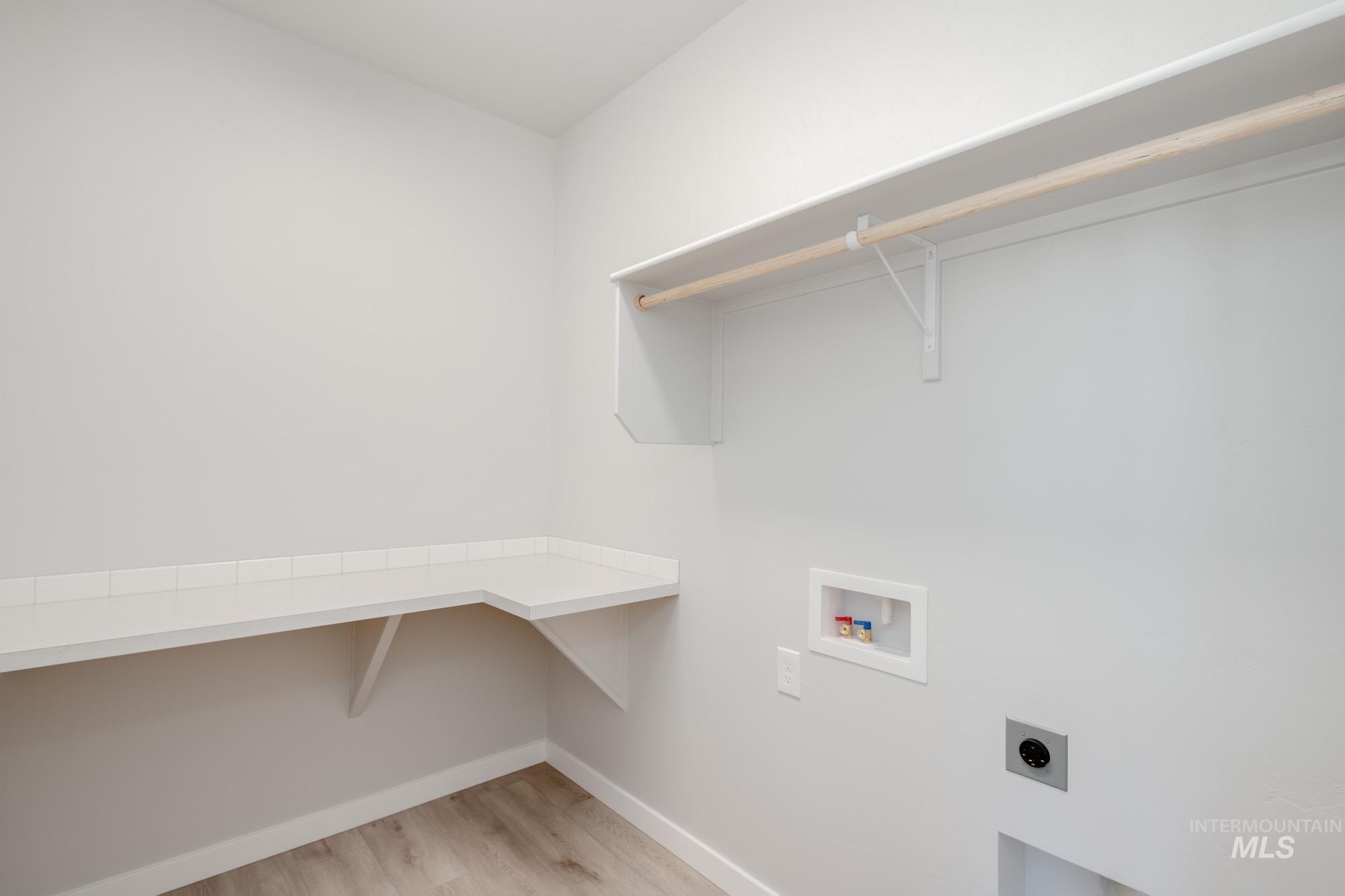 Laundry area featuring light wood-type flooring, washer hookup, and hookup for an electric dryer