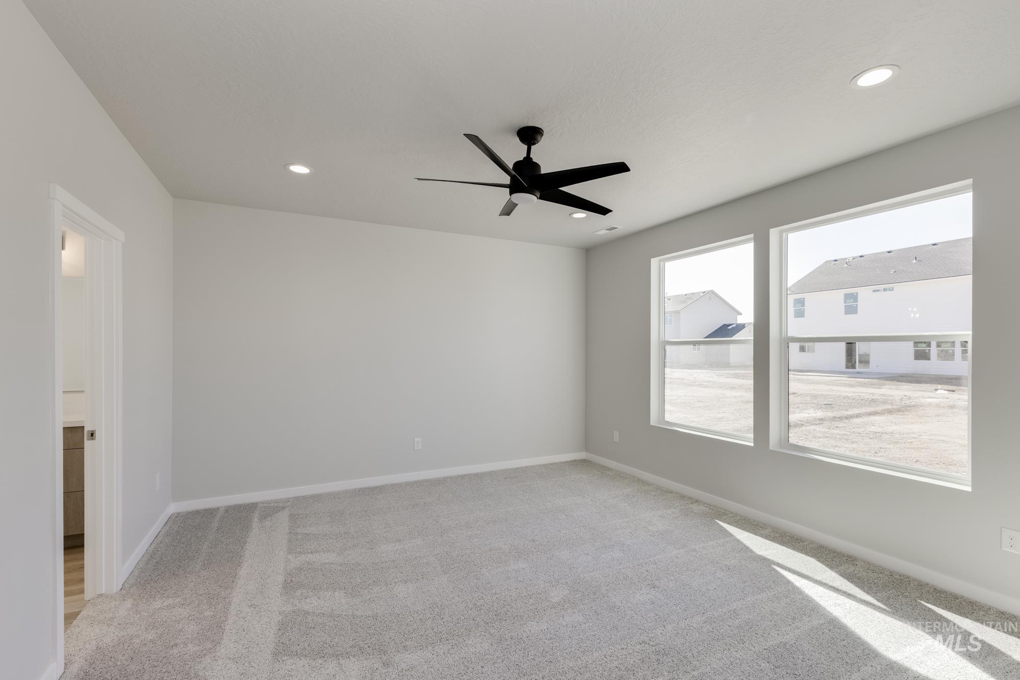 Spare room with light colored carpet, ceiling fan, and recessed lighting