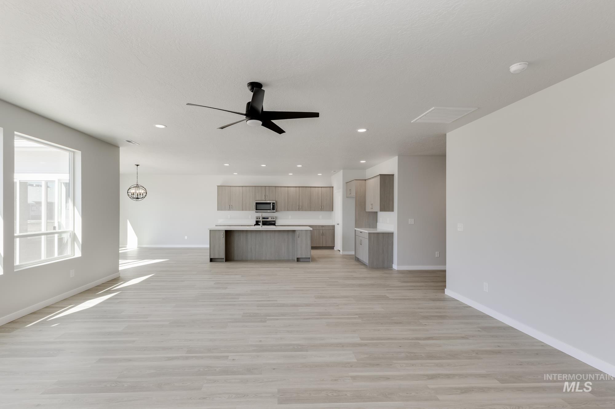 Unfurnished living room with light wood finished floors, recessed lighting, and a ceiling fan