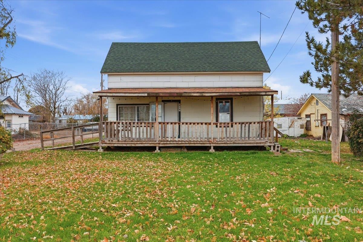 View of front of property featuring a wooden deck and a shingled roof