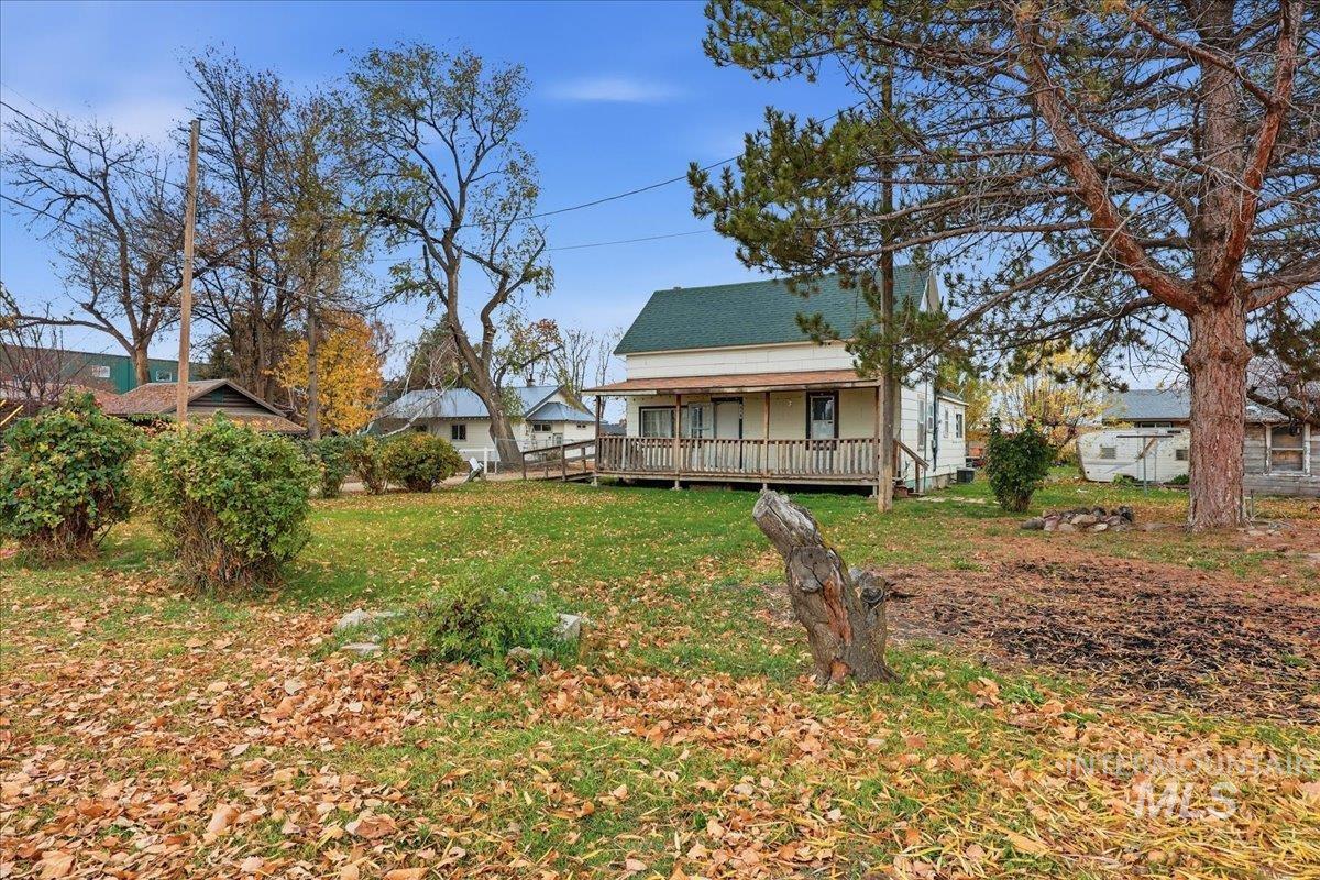 Rear view of house with covered porch and a lawn