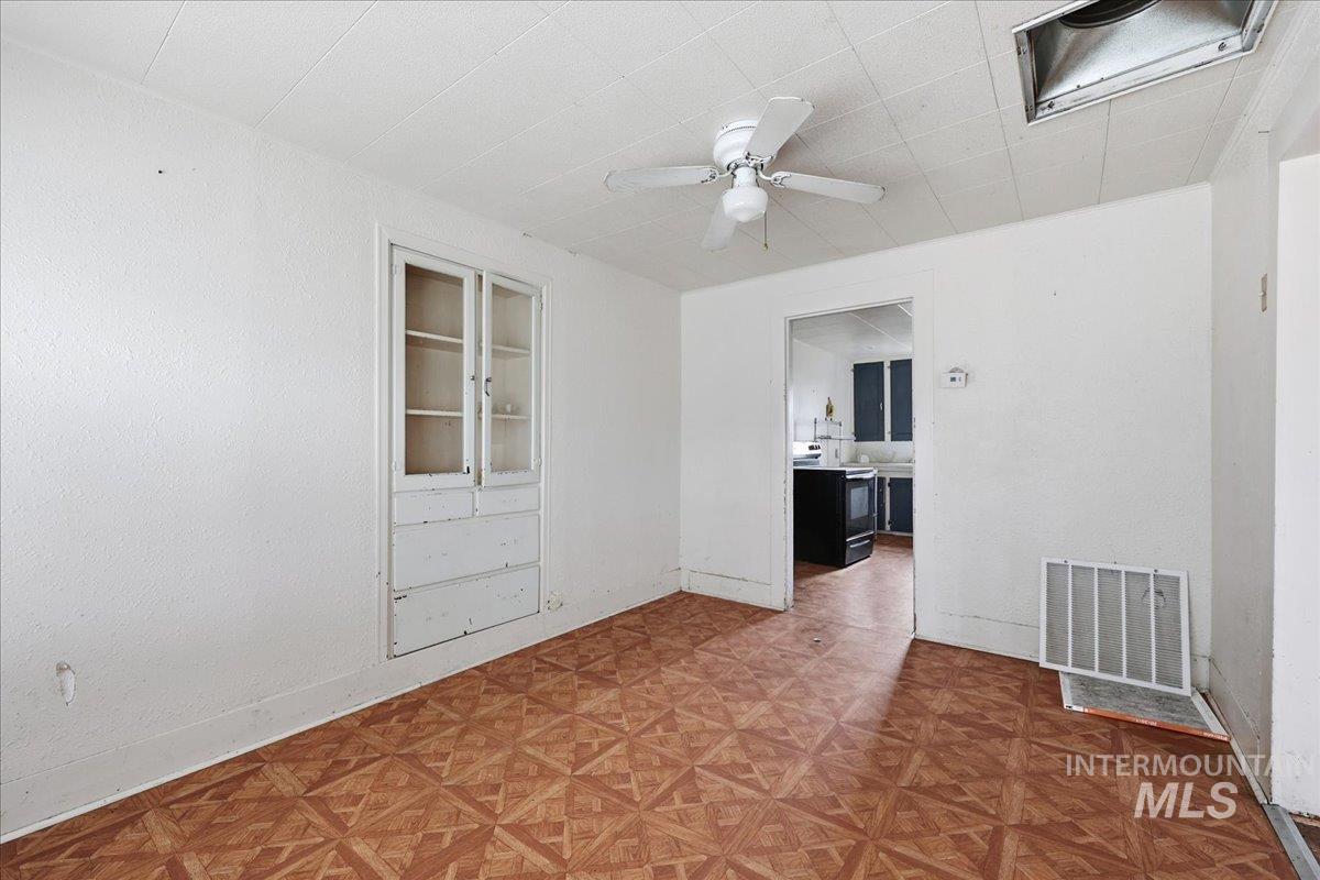 Unfurnished room featuring built in features and ceiling fan