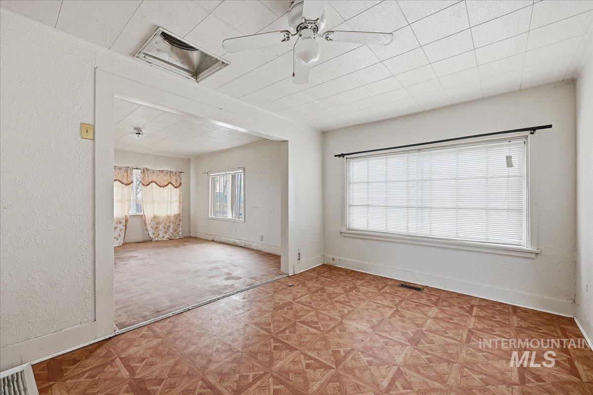 Empty room featuring ceiling fan and baseboards