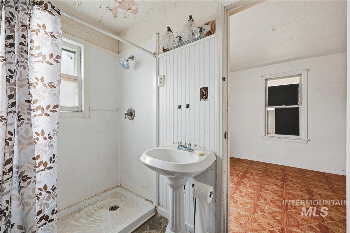 Full bath featuring a stall shower and light floors