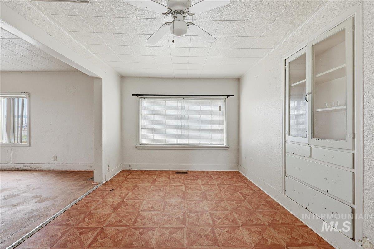 Spare room featuring ceiling fan and baseboards